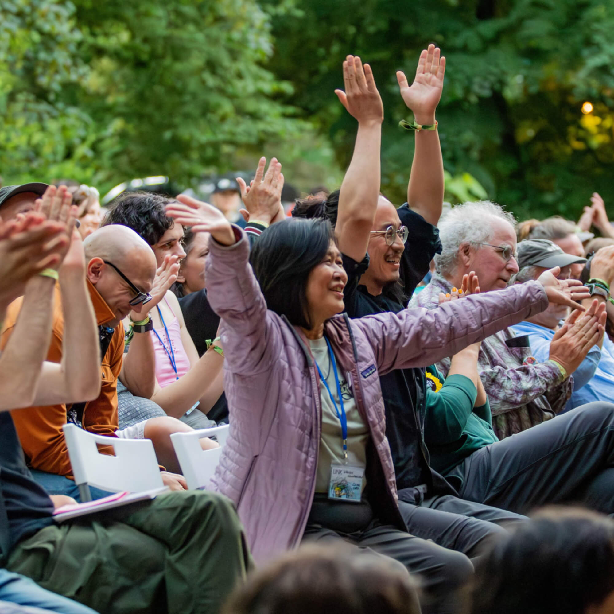 Wendy Hanamura, Tony Lai, Brewster Kahle and other participants clapping and raising hands into the sky during Closing Cerimony at Linden Theater